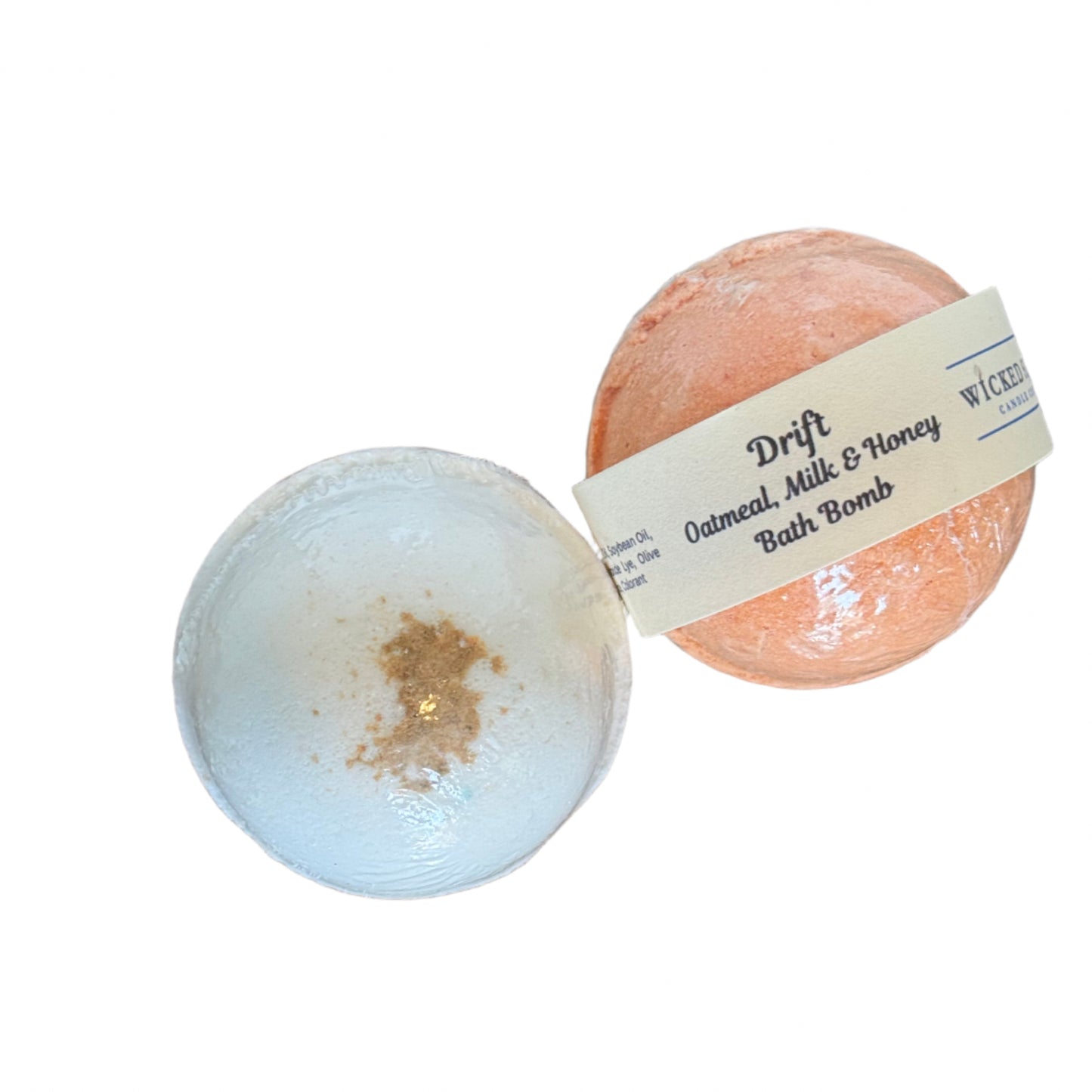 Two oat milk bath bombs, one tan and one white, on a clean white surface with a visible brand label.