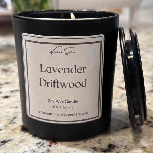 Candle labeled 'Lavender Driftwood' on a marble surface with black lid