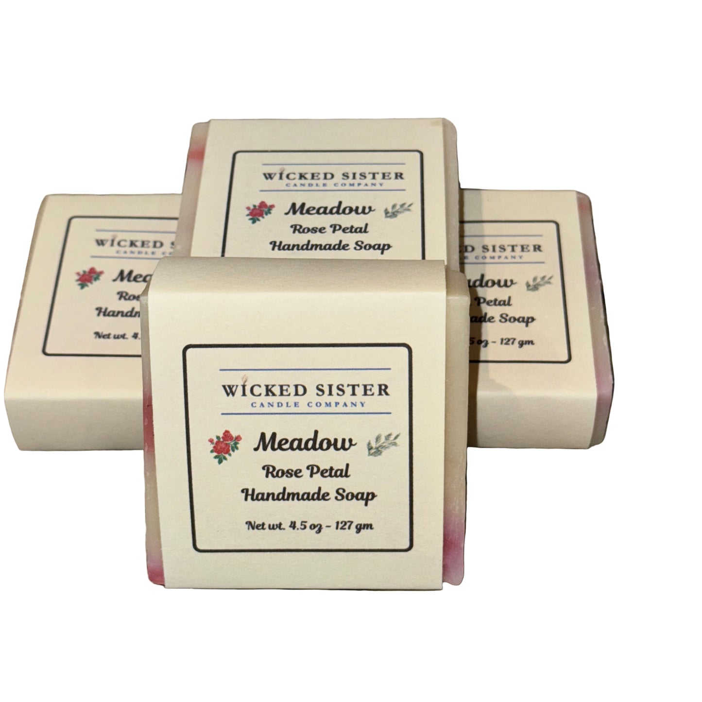 Handmade soap bars with 'Wicked Sister Candle Company' packaging on a white surface