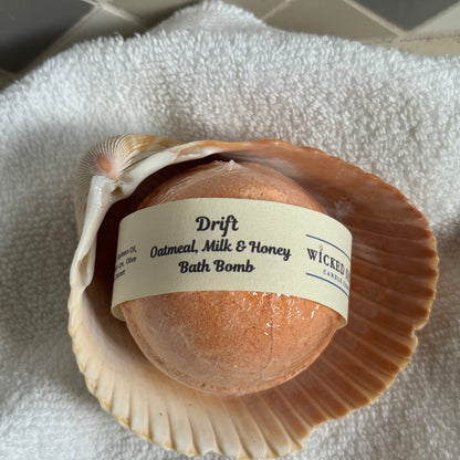 Oat milk bath bomb in a shell with a label on a towel